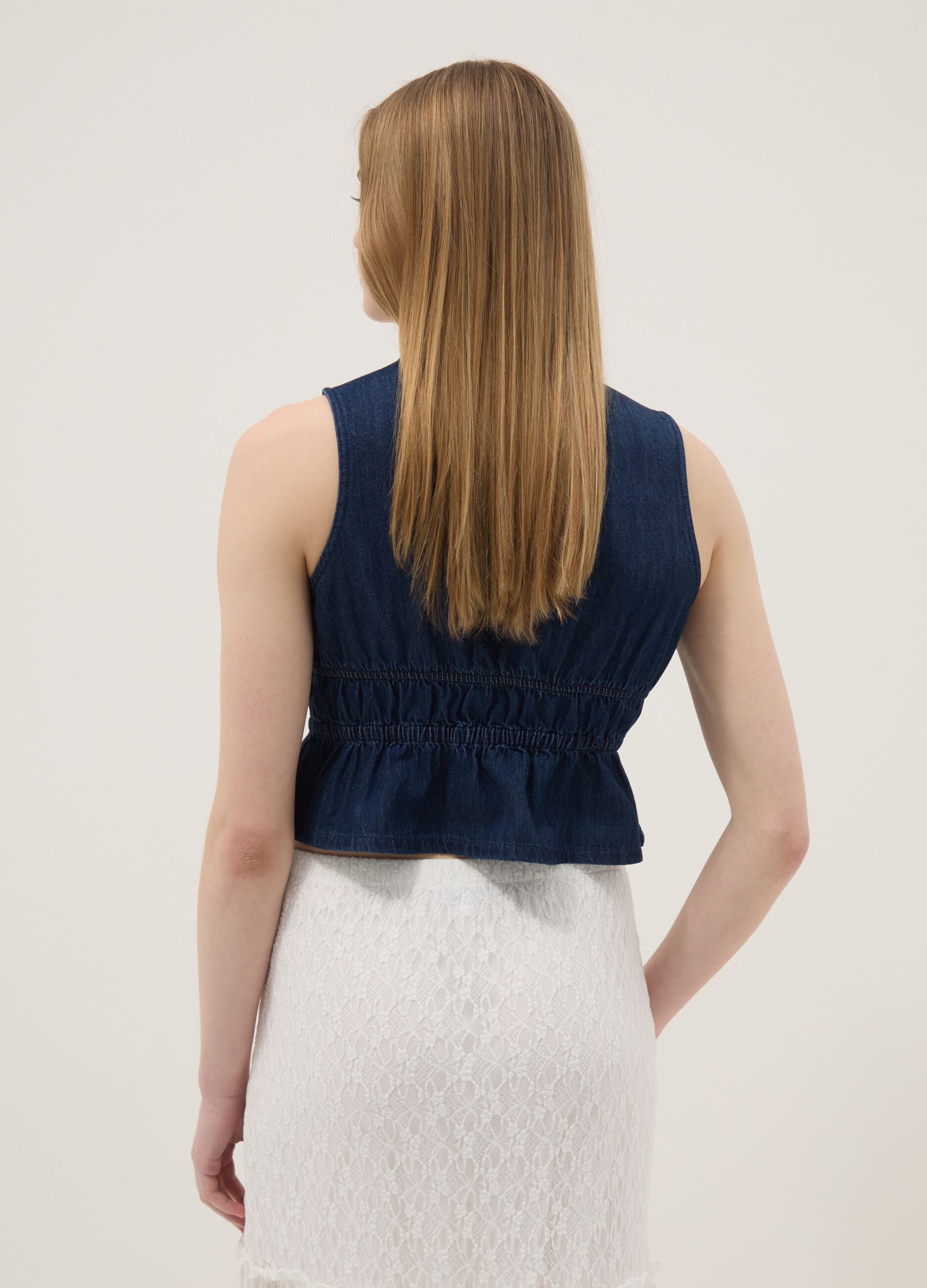 Blue sleeveless denim blouse in pure cotton, slim fit with tie fastening