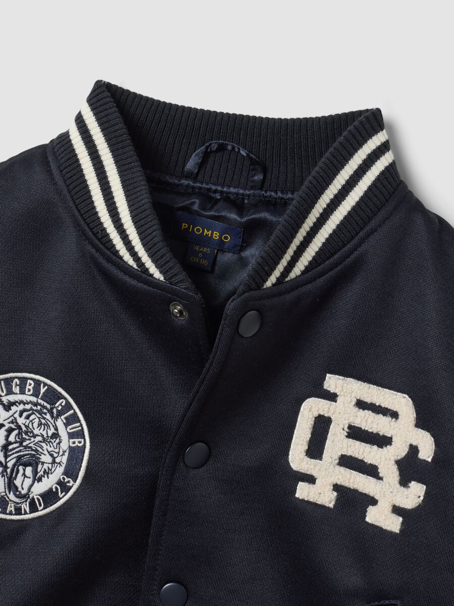 Blue varsity jacket with beige sleeves and print for boys_4