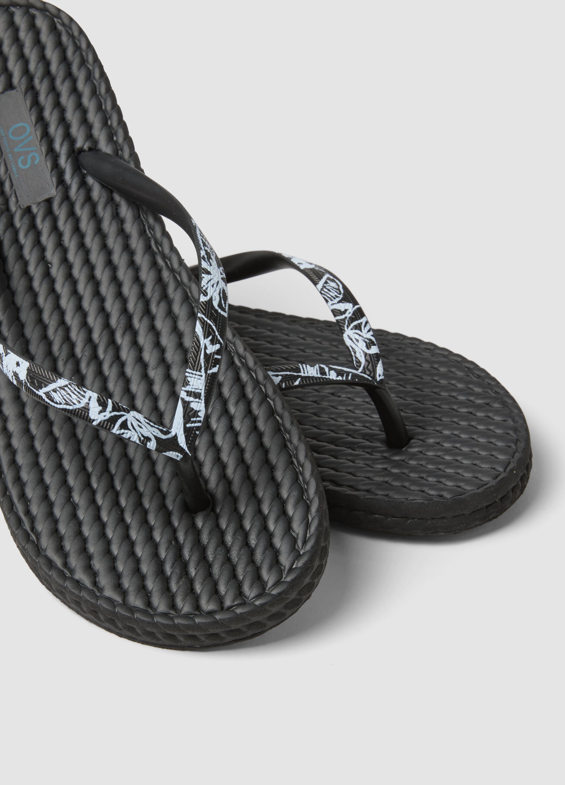 Black flip-flops with embellished straps and braided texture