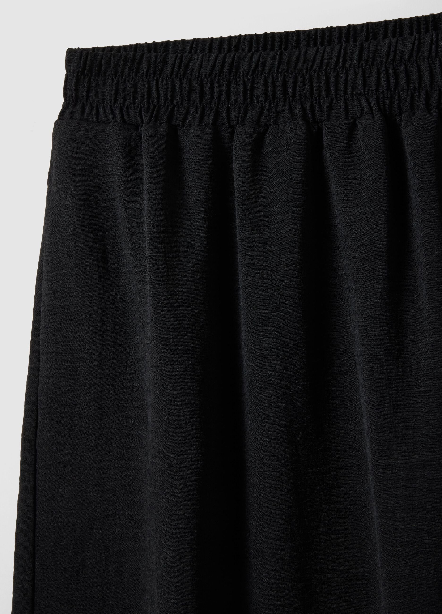Black long skirt with regular fit, elasticated waist and slit
