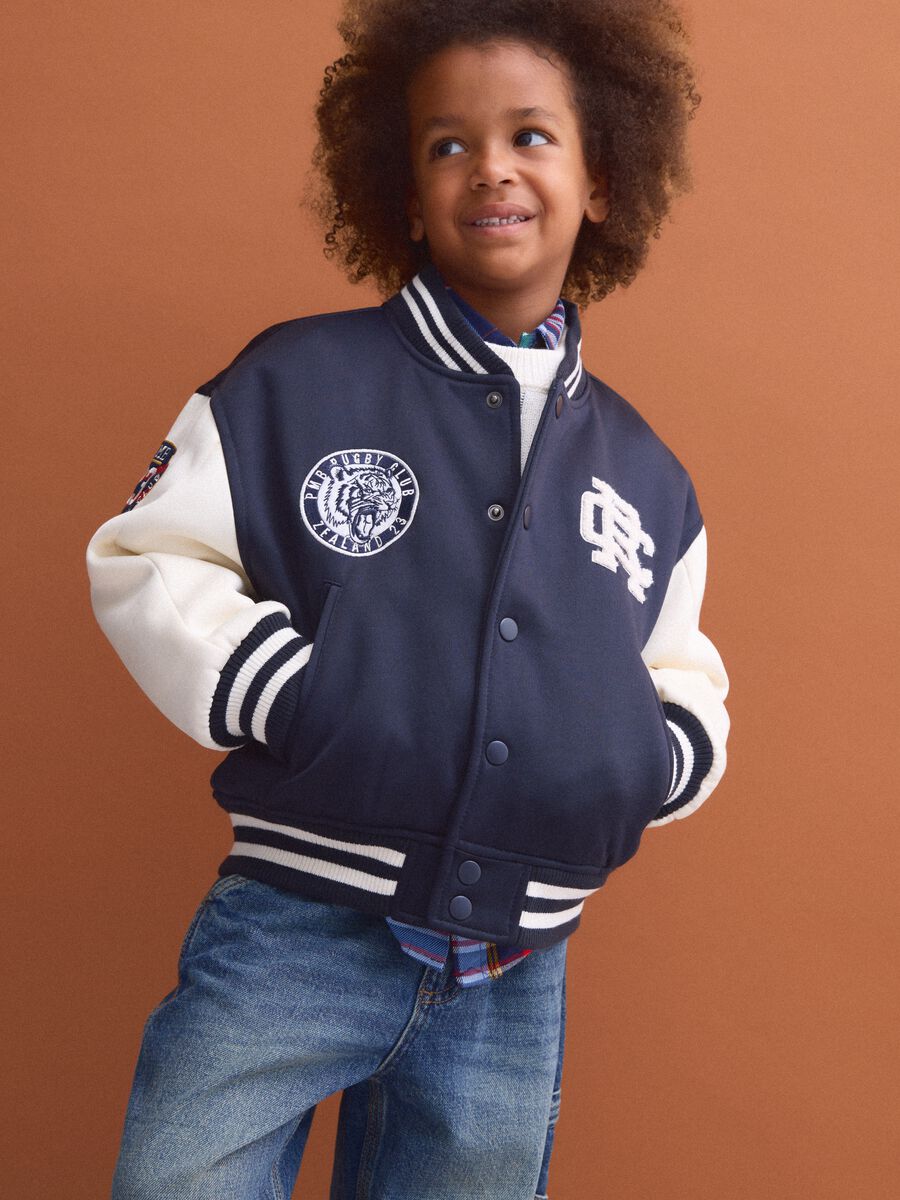 Blue varsity jacket with beige sleeves and print for boys_0
