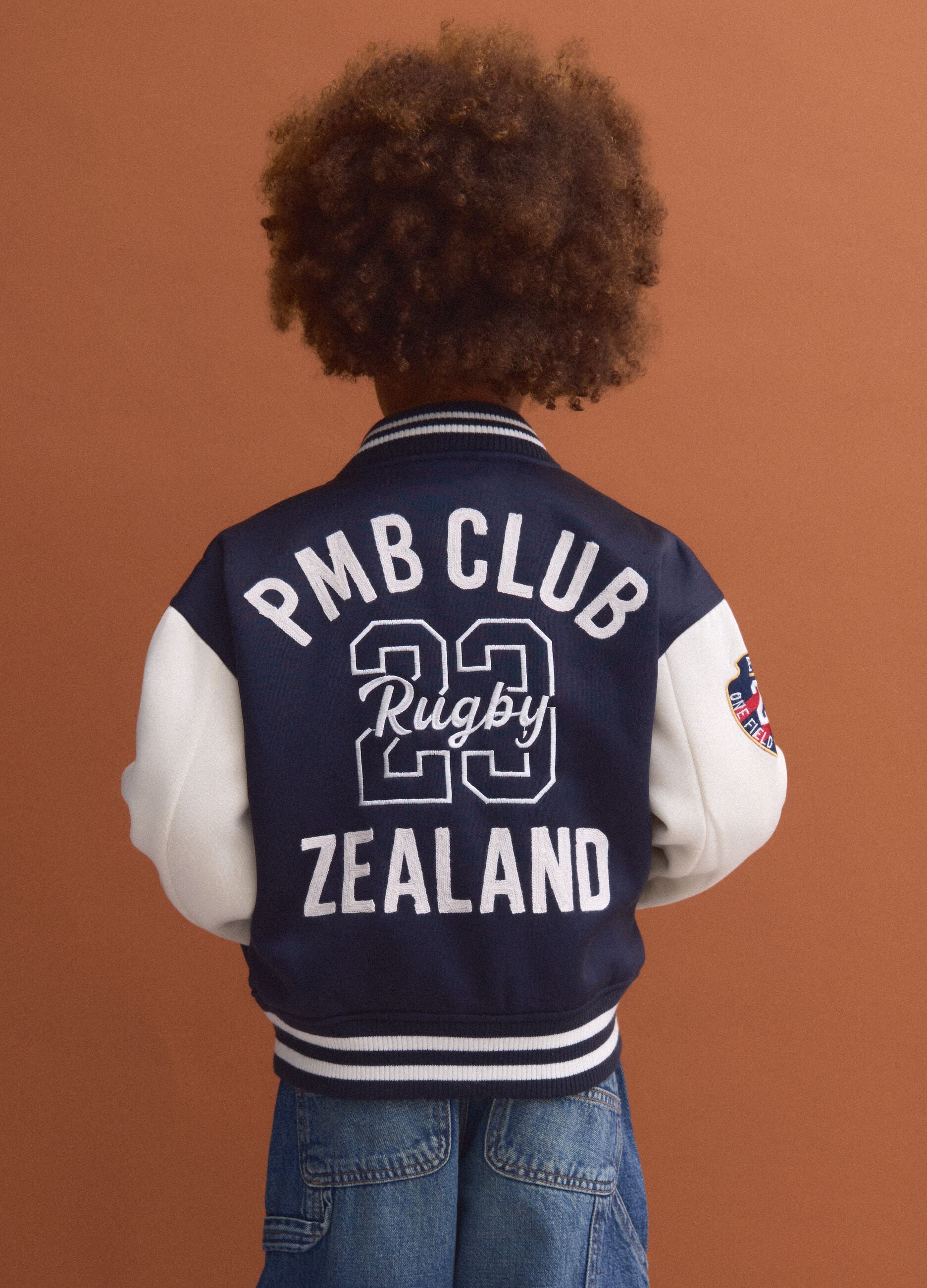 Blue varsity jacket with beige sleeves and print for boys