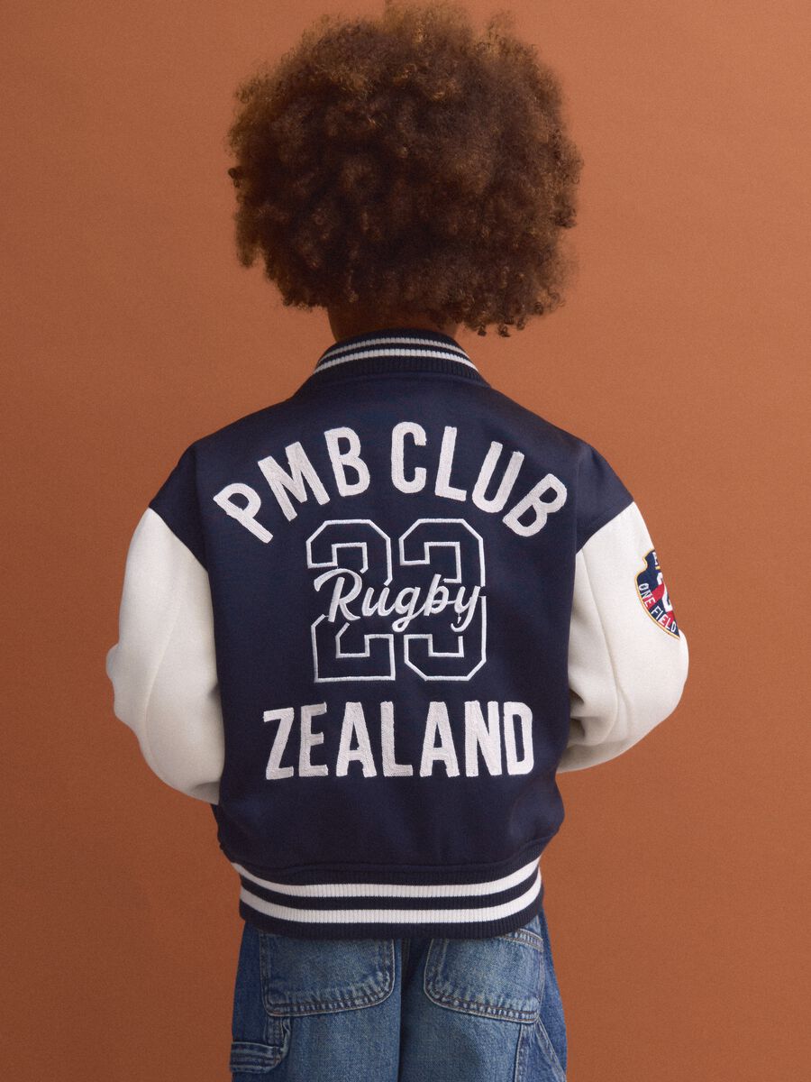 Blue varsity jacket with beige sleeves and print for boys_2