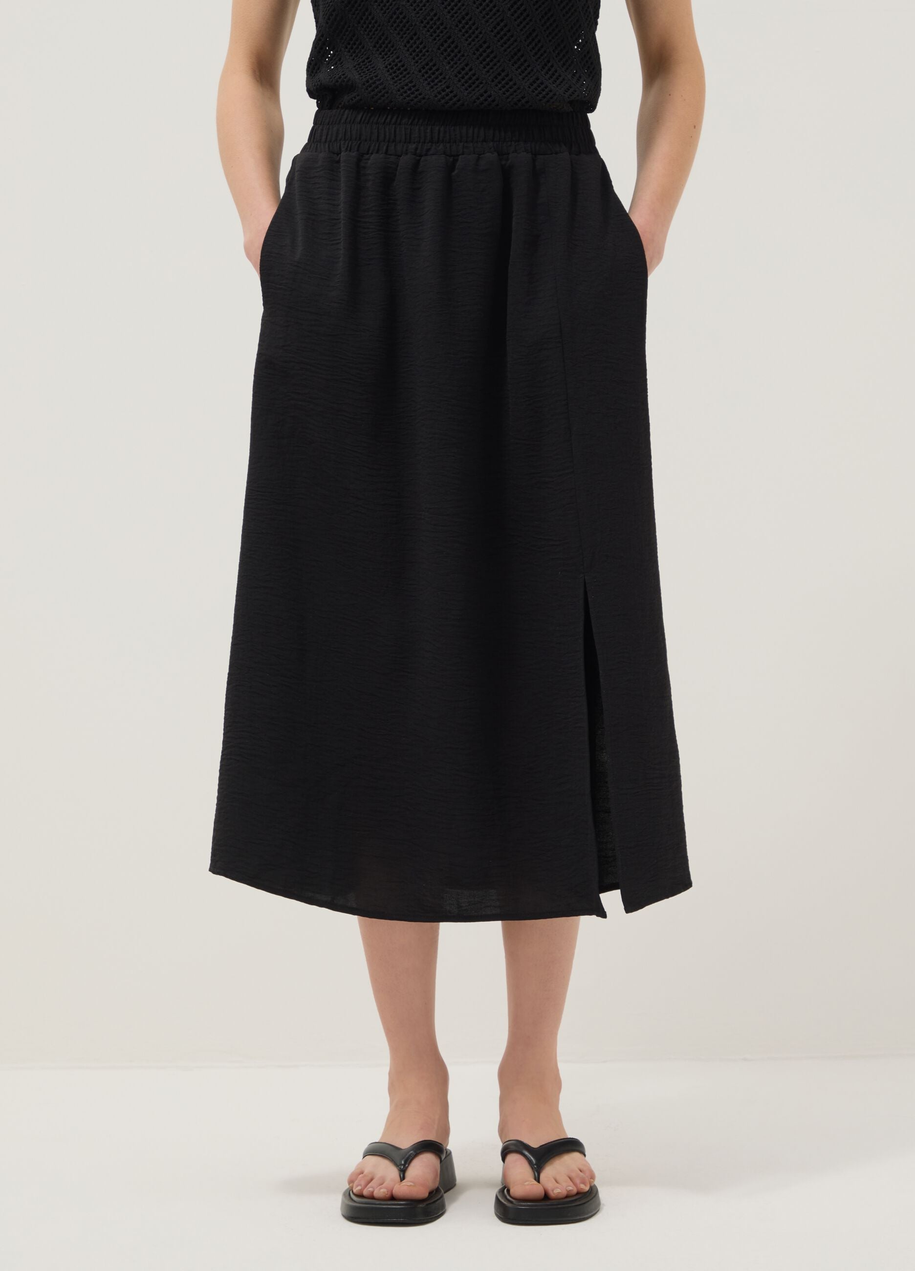 Black long skirt with regular fit, elasticated waist and slit