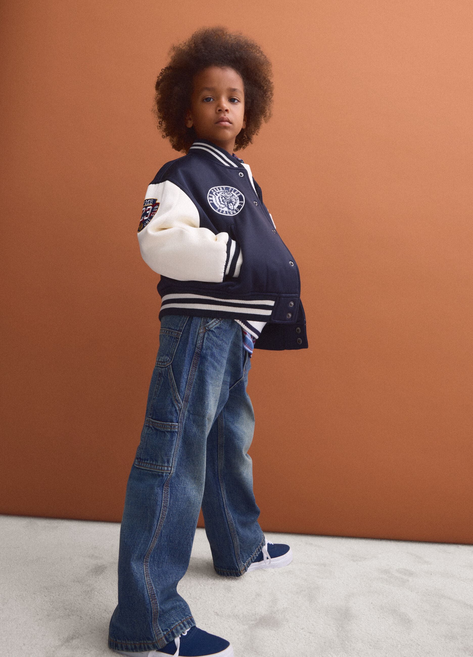 Blue varsity jacket with beige sleeves and print for boys