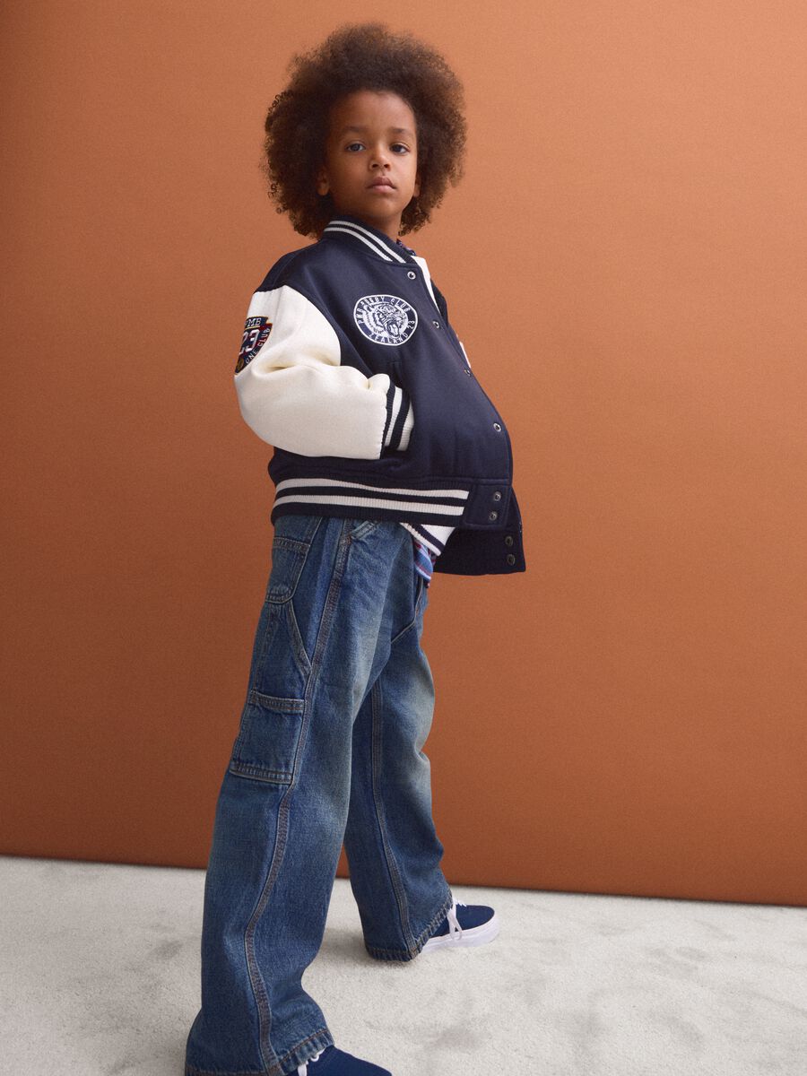 Blue varsity jacket with beige sleeves and print for boys_1