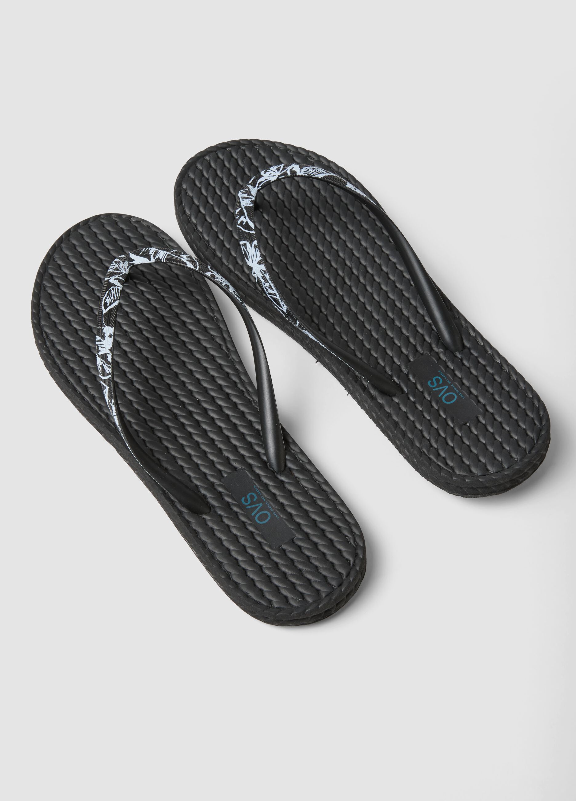 Black flip-flops with embellished straps and braided texture