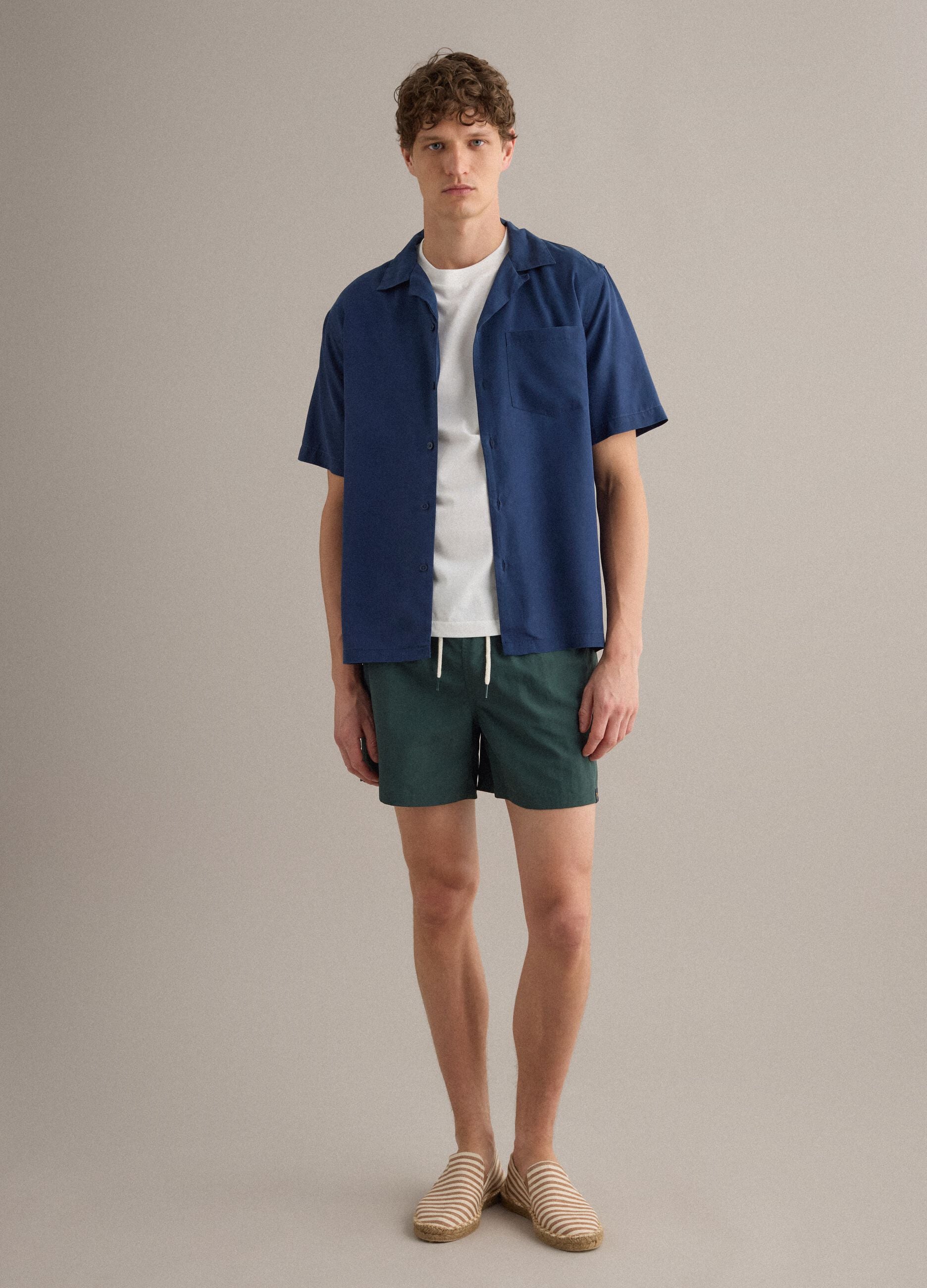 Green swim shorts with elasticated waistband and drawstring