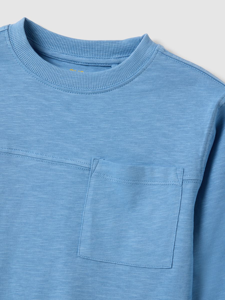 T-shirt azzurra da bambino in puro cotone con taschino oversize fit_3